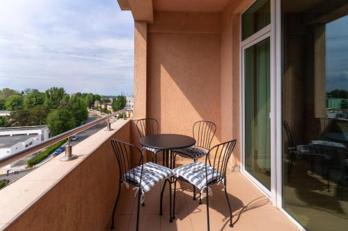 a balcony with chairs and a table and a window at Rezident Eforie Nord in Eforie Nord