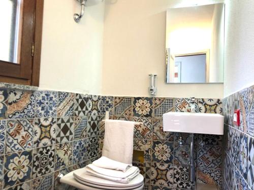 a bathroom with a toilet and a sink and a mirror at panoramic LOFT Fora e ' Muros with sea view common terrace , Ammentos Posada in Posada