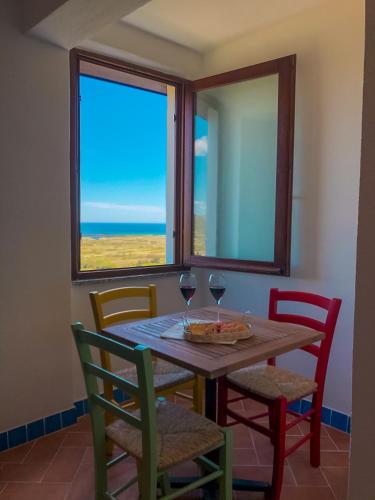 a dining room with a table and chairs and a window at panoramic LOFT Fora e ' Muros with sea view common terrace , Ammentos Posada in Posada