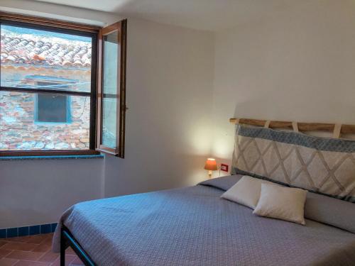 a bedroom with a bed and a window at panoramic LOFT Fora e ' Muros with sea view common terrace , Ammentos Posada in Posada