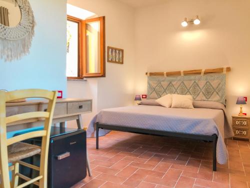 a bedroom with a bed and a desk and a table at panoramic LOFT Fora e ' Muros with sea view common terrace , Ammentos Posada in Posada