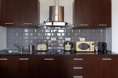 a kitchen counter with a microwave and a sink at Rezident Eforie Nord in Eforie Nord
