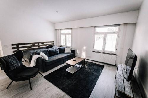 una sala de estar con un sofá y una mesa en SleepWell House Pyhätunturi with Sauna close to lake, en Pelkosenniemi