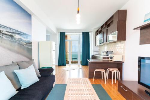 a living room with a couch and a kitchen at Rezident Eforie Nord in Eforie Nord