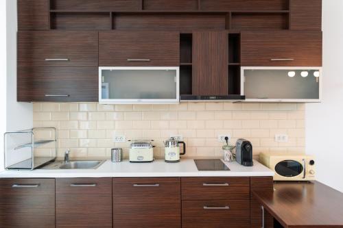 a kitchen with wooden cabinets and a counter top at Rezident Eforie Nord in Eforie Nord