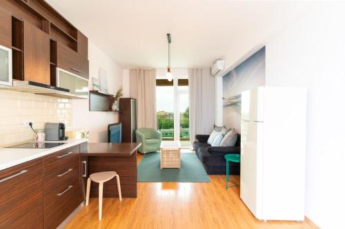 a kitchen and living room with a couch at Rezident Eforie Nord in Eforie Nord