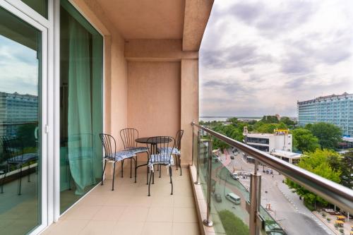 a balcony with chairs and a table on a building at Rezident Eforie Nord in Eforie Nord