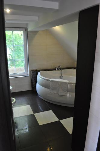 a bath tub in a bathroom with a window at Apartament Stara Leśniczówka in Polnica