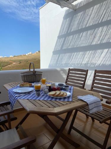 una mesa de picnic con comida y bebida en el balcón en Spanos Apartments en Áyios Pétros