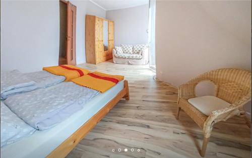 - une chambre avec un grand lit et une chaise dans l'établissement Diament Darłowo, à Darłowo