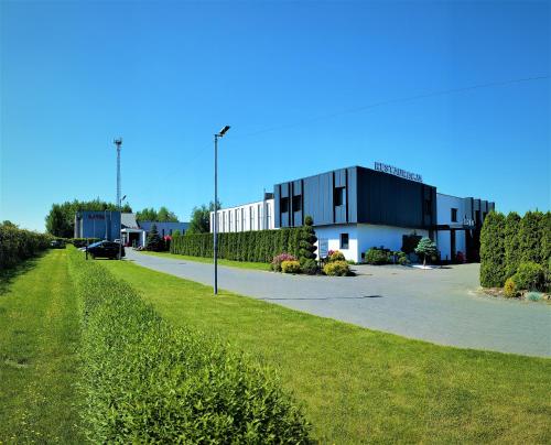 a parking lot with a building in the background at Hotel Eden in Rzgów