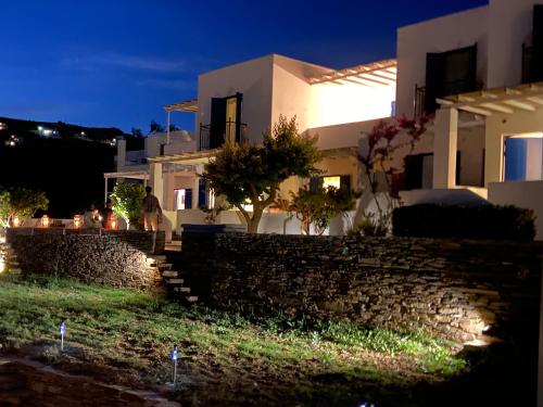 a man walking down a stone wall in front of a house at Spanos Apartments in Agios Petros