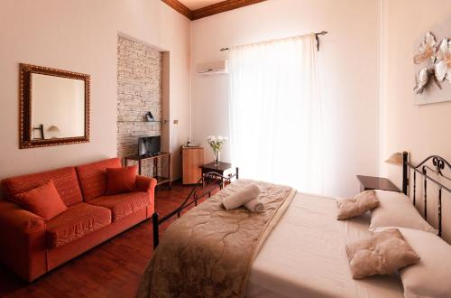 ein Schlafzimmer mit einem Bett und einem roten Sofa in der Unterkunft Hotel Concordia in Palermo