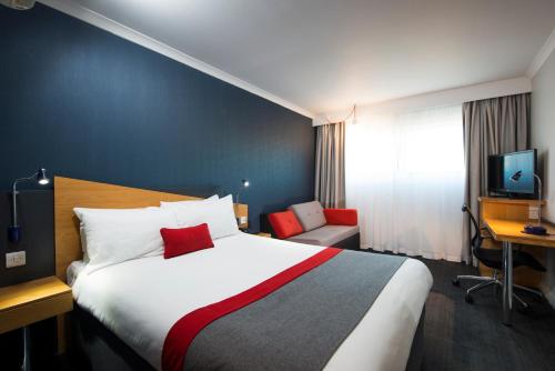a hotel room with a large bed and a desk at Holiday Inn Express Derby Pride Park by IHG in Derby