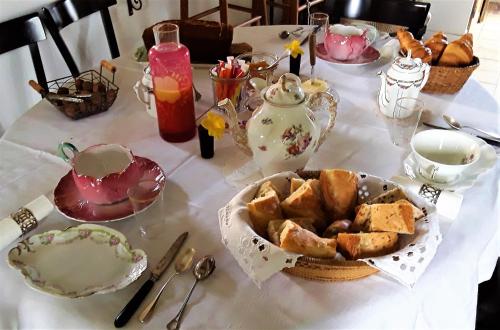 een tafel met een bord brood en een theeservies bij Loge & Broc in La Possonnière