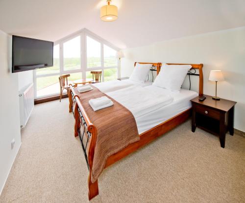 a bedroom with a large bed and a flat screen tv at Hotel Mona Lisa Wellness & Spa in Kołobrzeg