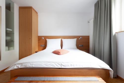a bedroom with a bed with a wooden headboard at Storchen Restaurant Hotel in Bad Krozingen