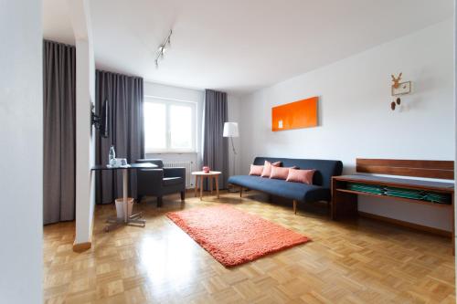 a living room with a blue couch and a chair at Storchen Restaurant Hotel in Bad Krozingen