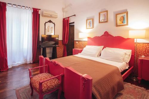 um quarto vermelho com uma cama e uma televisão em Cinematocasa Suite em Palermo