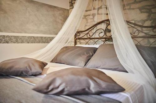 two pillows on a bed with a canopy at Rooms Konoba Pjero in Buje