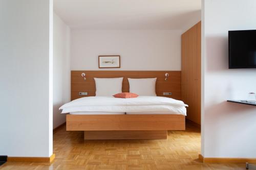a bedroom with a bed and a tv on a wall at Storchen Restaurant Hotel in Bad Krozingen