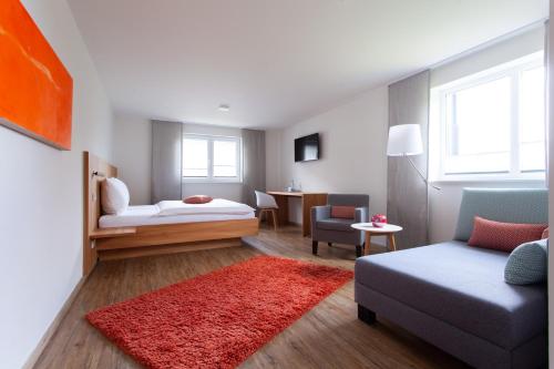 a small living room with a couch and a bed at Storchen Restaurant Hotel in Bad Krozingen