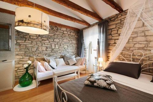 a living room with a couch and a stone wall at Rooms Konoba Pjero in Buje