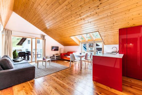Patergassen的住宿－Quercus Appartements contactless check-in，一间厨房和一间带红色橱柜的客厅