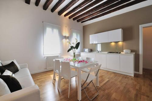 Il comprend un salon avec une table blanche et une cuisine. dans l'établissement Cannaregio Suite - Colleoni Holidays, à Venise