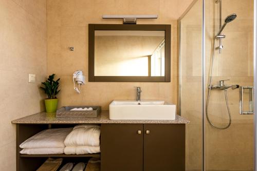 a bathroom with a sink and a shower at Emerald Ville in Stoupa