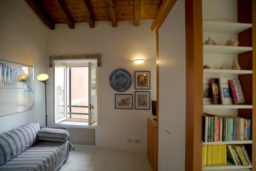 sala de estar con sofá y ventana en Borgo Antico - Casa del commodoro, en Tellaro