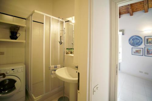 a bathroom with a sink and a washing machine at Borgo Antico - Casa del commodoro in Tellaro