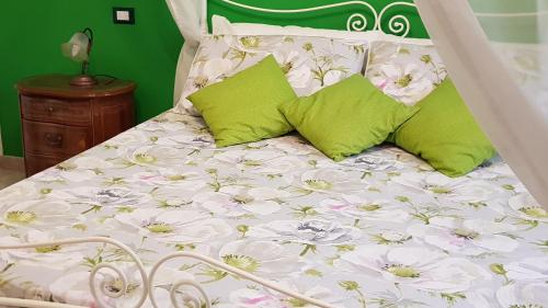 a white bed with flowers on it with green walls at Amanda's Dream in Taranto