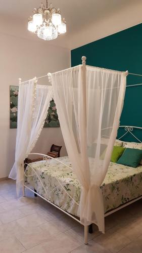 a bedroom with a bed with curtains and a chandelier at Amanda's Dream in Taranto