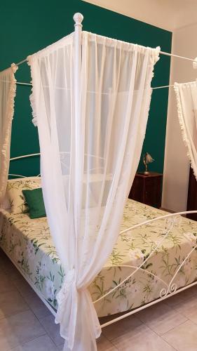 a bedroom with a bed with white curtains at Amanda's Dream in Taranto
