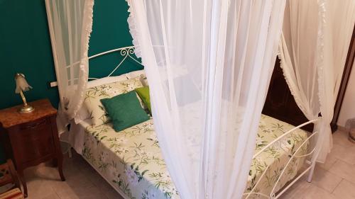 a bedroom with a bed with curtains and a green pillow at Amanda's Dream in Taranto