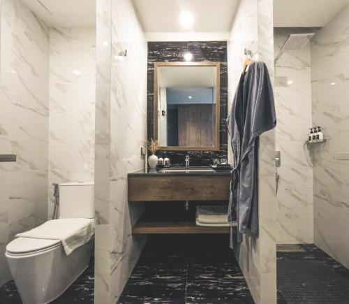 a bathroom with a sink and a toilet and a mirror at Spice House Chiang Mai in Chiang Mai