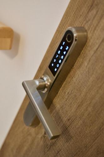 a remote control sticking out of a wooden table at R&J apartmány in Broumov