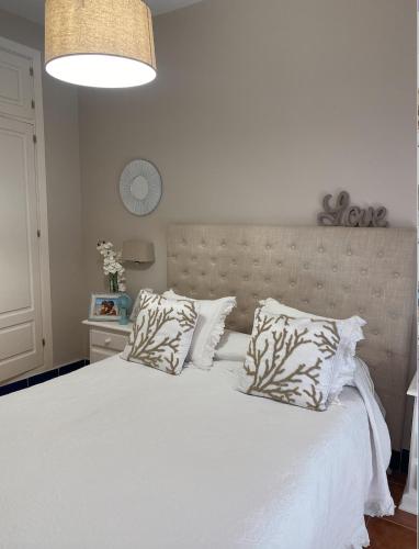 a bedroom with a large white bed with two pillows at Lomas de Sancti Petri in Cádiz