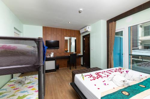 a bedroom with a bed and a desk in a room at Hotel Sole in Patong Beach