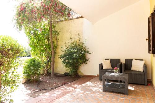 a patio with two couches and a tree at Is Benas Country Lodge in San Vero Milis
