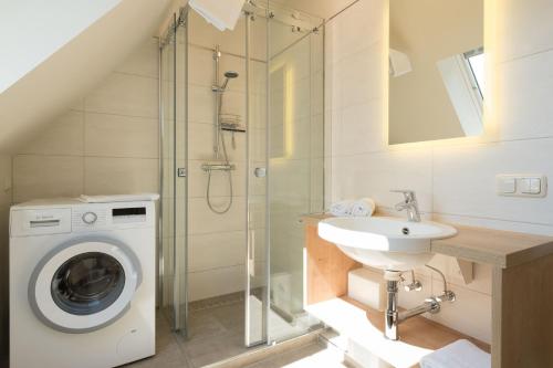 a bathroom with a washing machine and a sink at Ferienhaussiedlung Strandperlen Buchenhof 6a (Typ III) in Wustrow