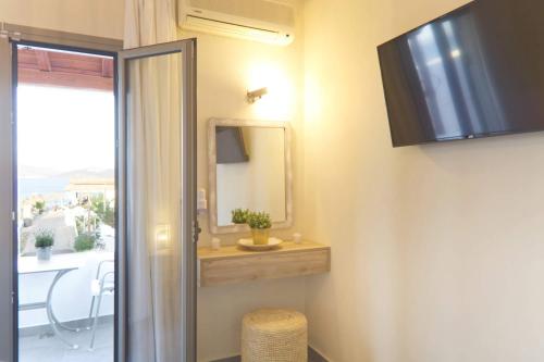 baño con espejo y puerta corredera de cristal en Saronic View, en Skala