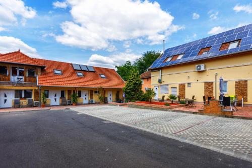 un groupe de bâtiments avec des panneaux solaires sur leurs toits dans l'établissement Central Panzió Gyula, à Gyula