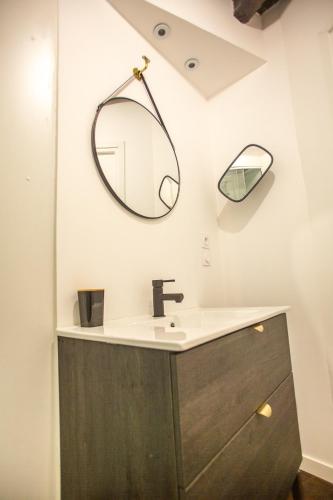a bathroom with a sink and a mirror at L'Escapade à Lascaux in Montignac