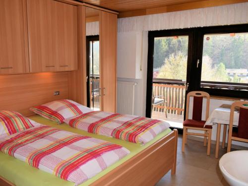 a bedroom with a bed and a balcony at Gaestehaus Grau in Egloffstein