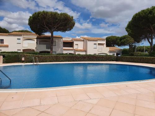 une grande piscine bleue devant un immeuble dans l'établissement Appartement Cap d'Agde - 6 personnes, au Cap d'Agde