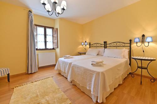 1 dormitorio con 1 cama grande con sábanas blancas en Puente del Narcea en Cangas del Narcea