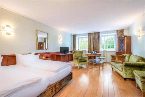 a hotel room with a bed and a desk at Hotel Schloss Wilkinghege in Münster