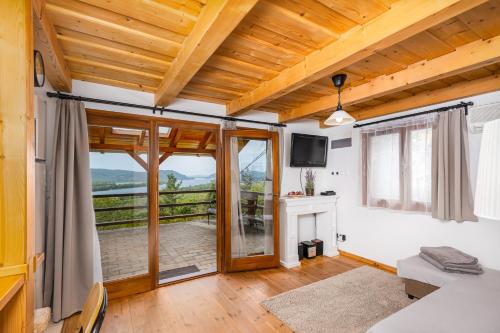 a room with a bed and a balcony with a television at Sunset Hill Vendégház Zebegény in Zebegény